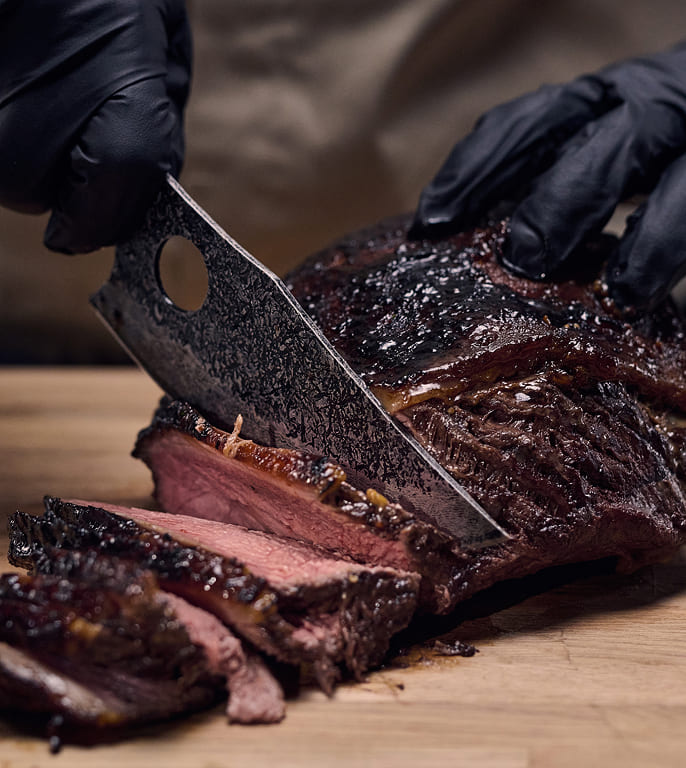 Matsato Osuren chef knife slicing a medium-rare steak into thin strips